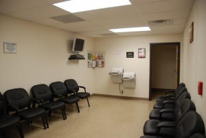 A room with several black chairs and a television.